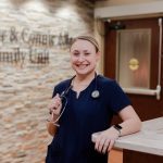 Nurse smiling in front of Anderson Hospital visitor desk