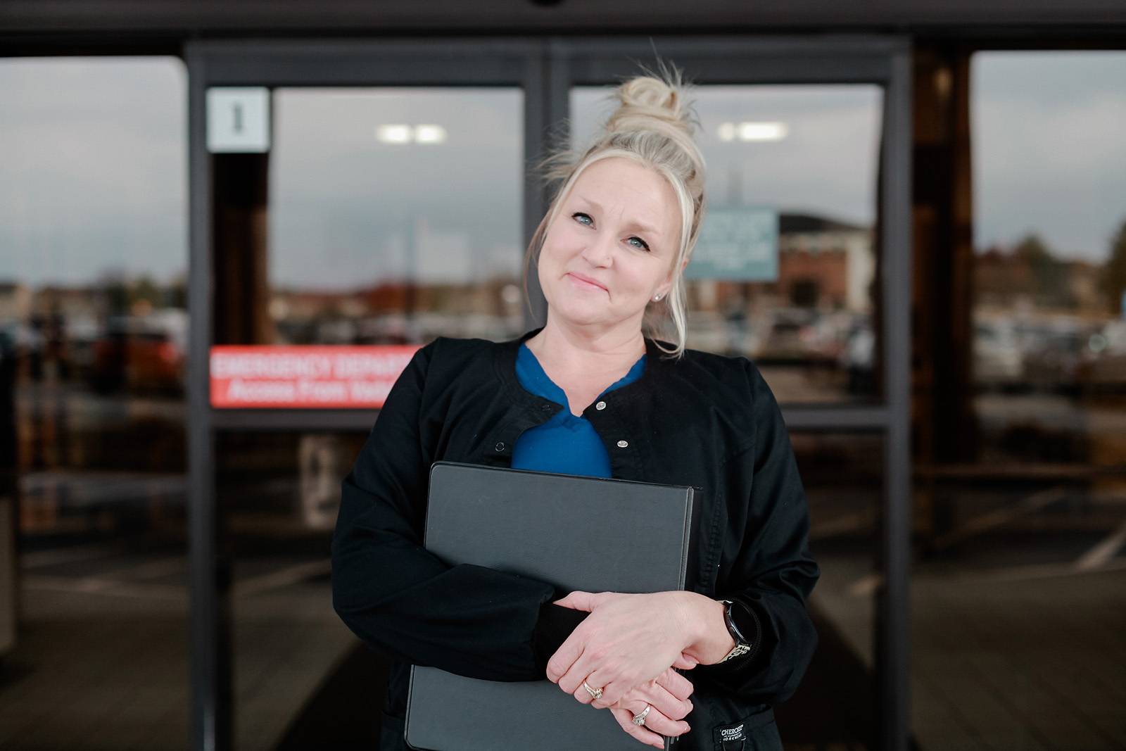Anderson Home Health Caretaker smiling in front of hospital doors