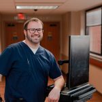 Male nurse smiling in Anderson Hospital hallway