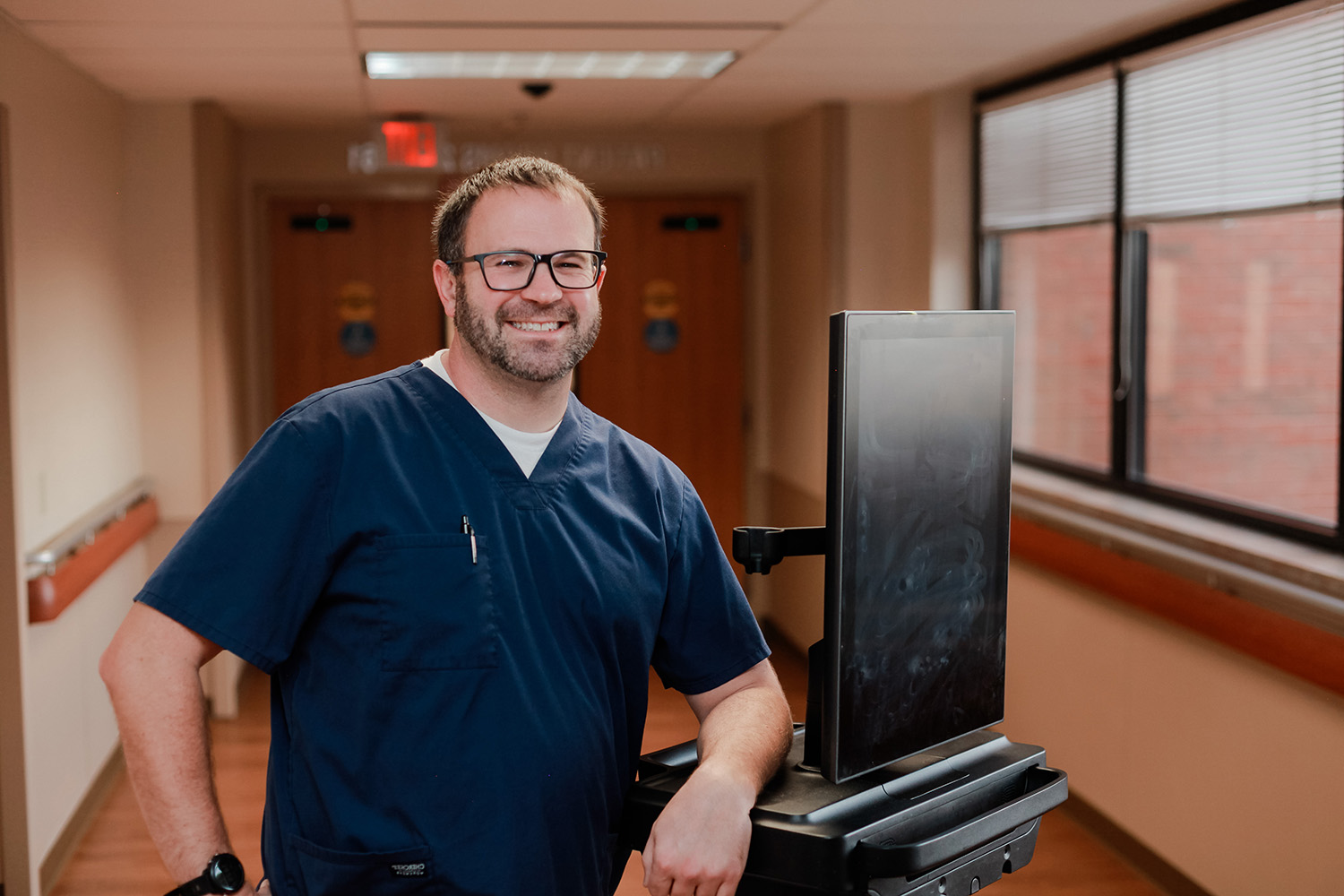 Male nurse smiling in Anderson Hospital hallway