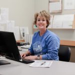Anderson Hospital staff member smiling at desk in an office